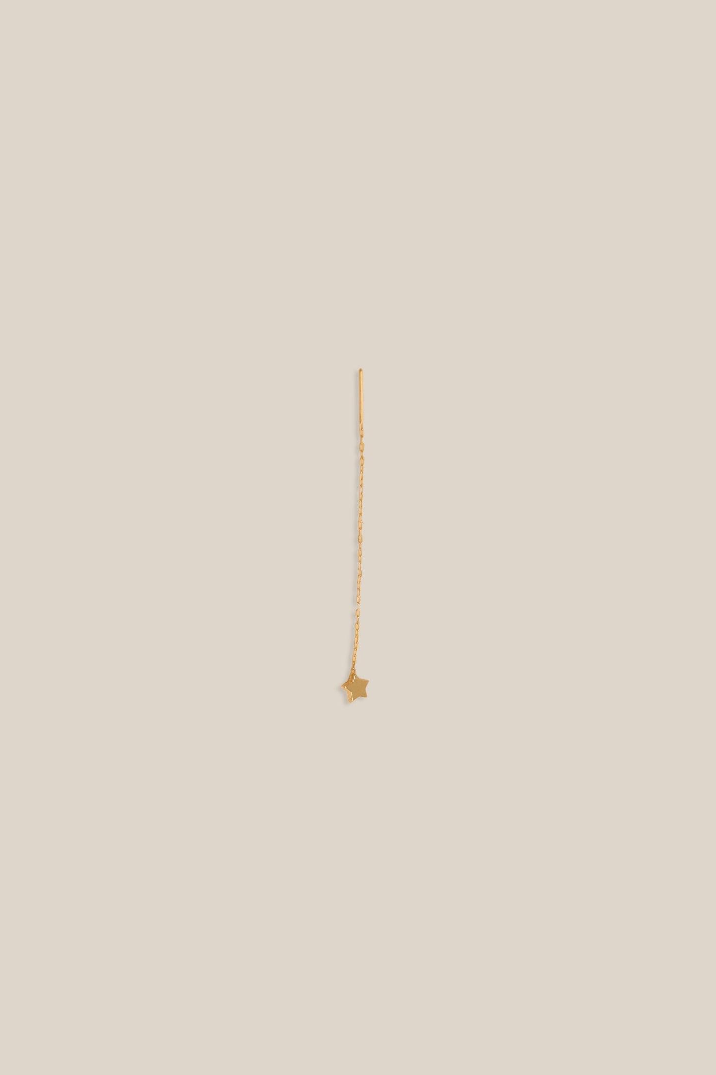 Gold necklace on a beige background