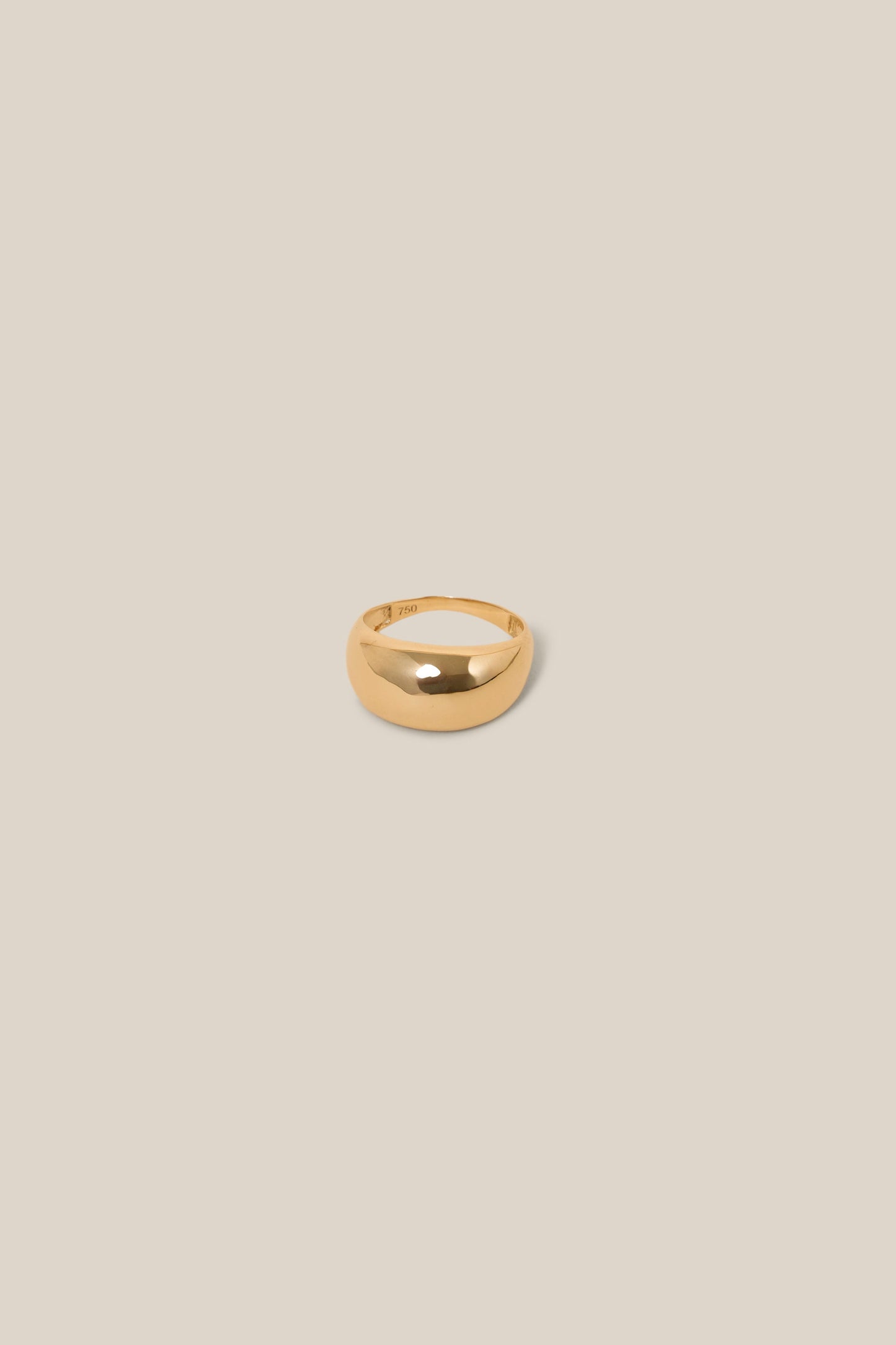 Gold ring on a beige background