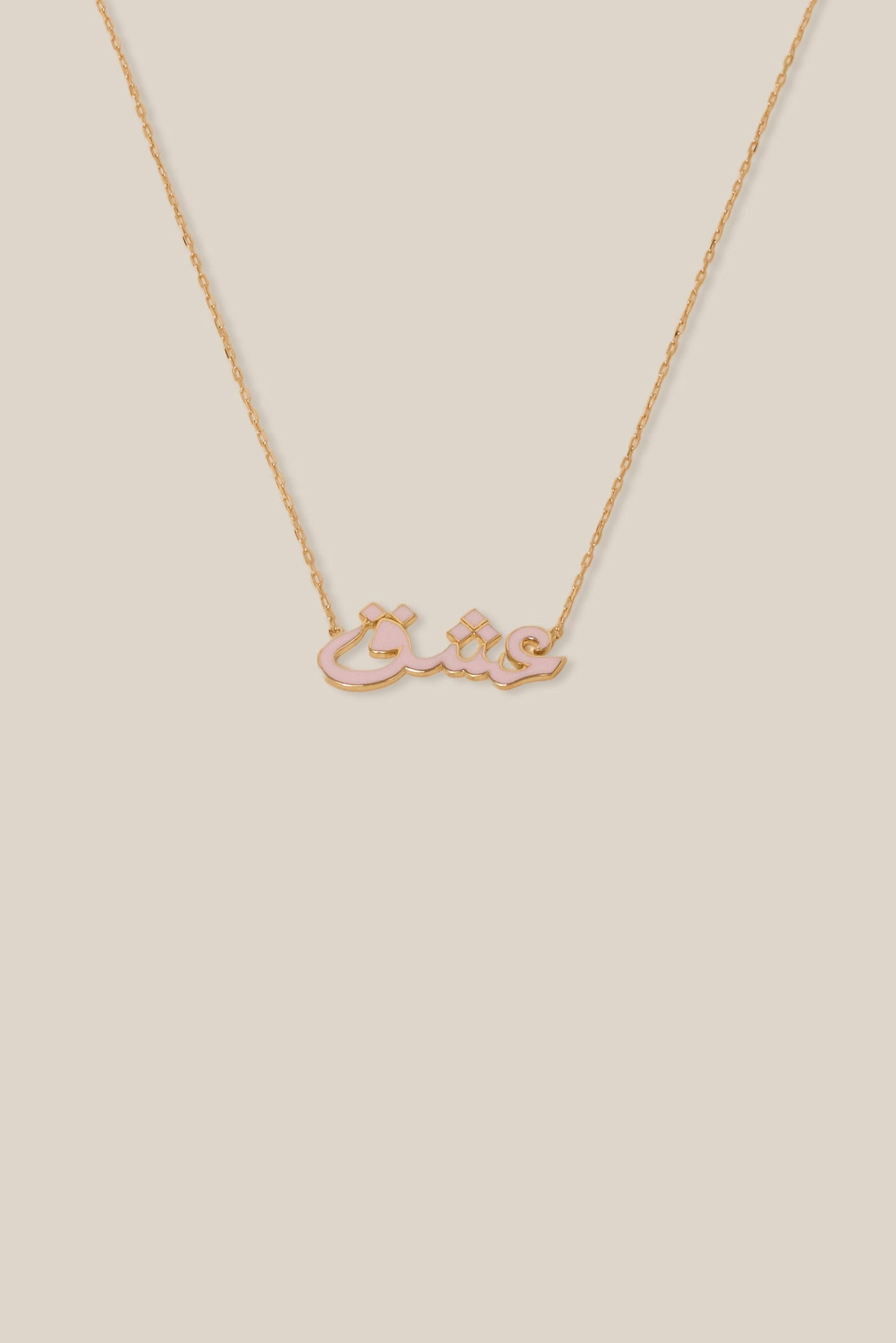Gold necklace with a bow-shaped pendant on a beige background