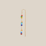 Long earring with colorful beads on a beige background