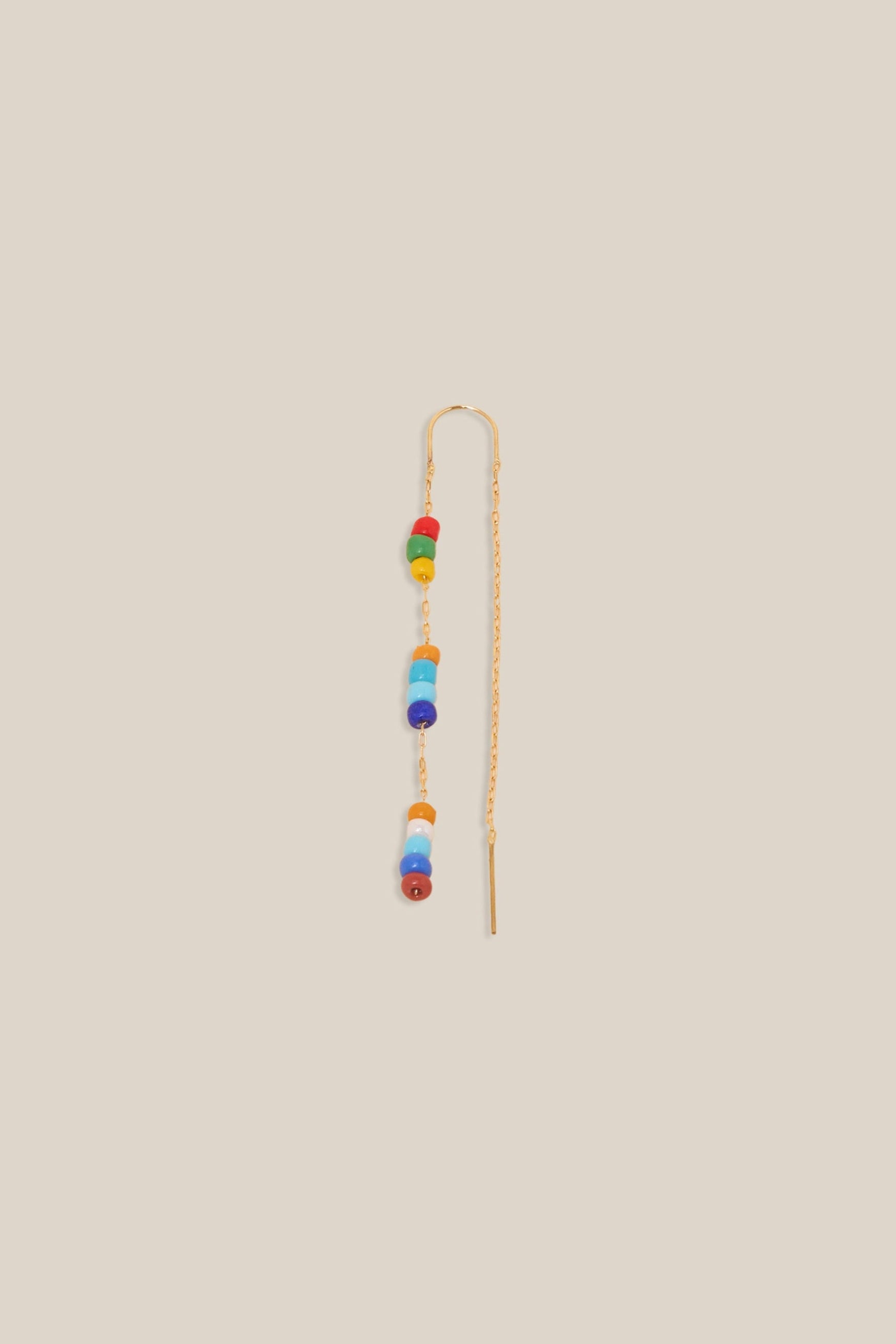 Long earring with colorful beads on a beige background