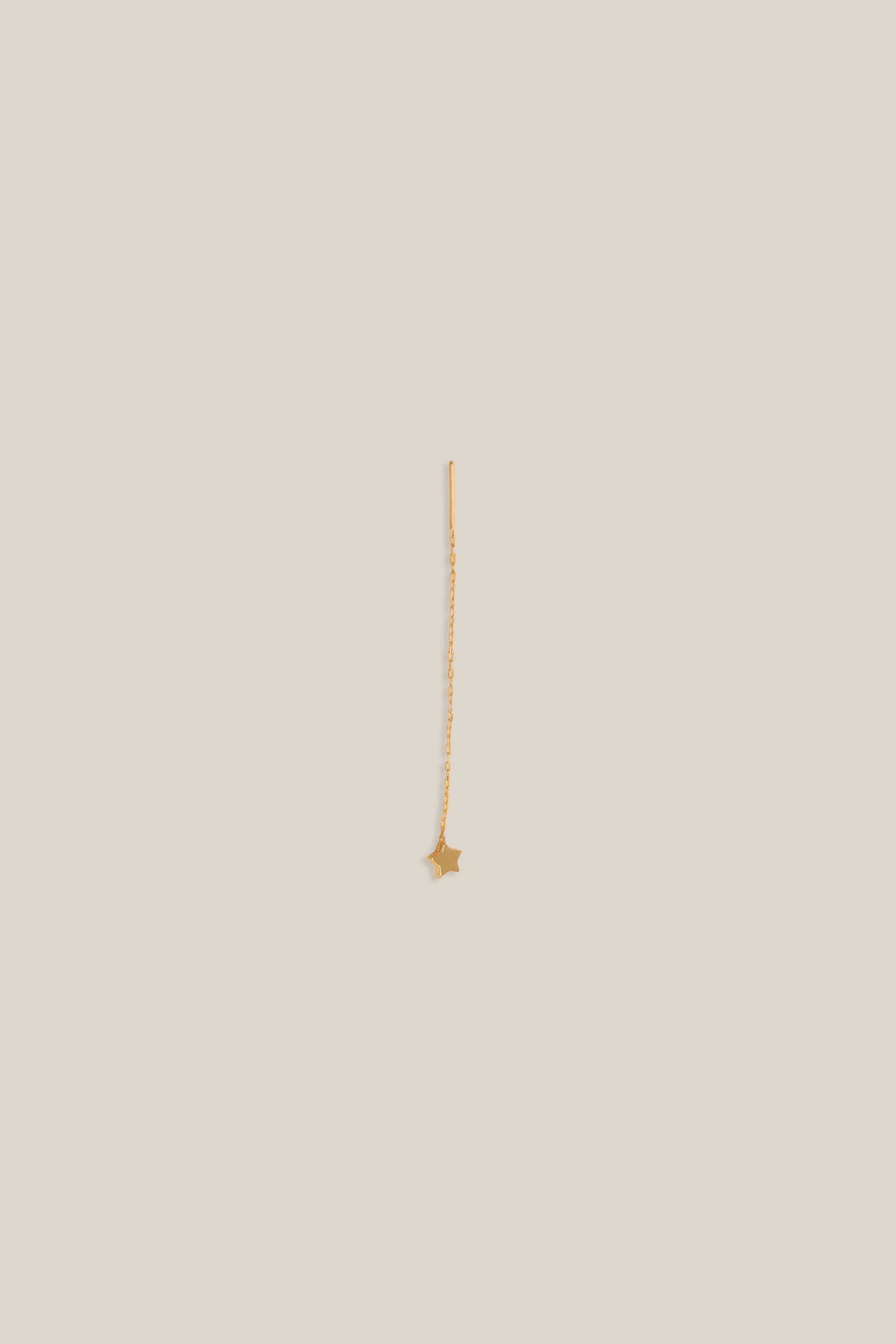 Gold necklace on a beige background