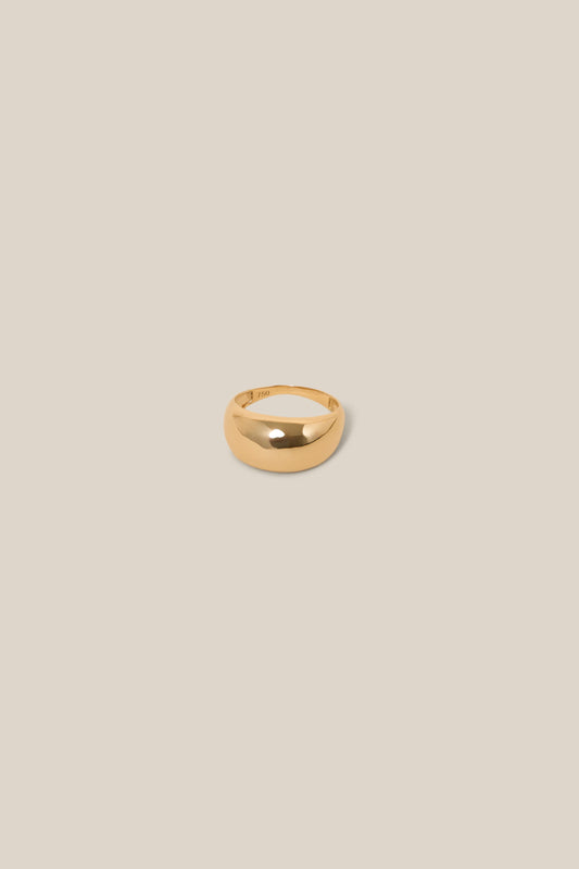 Gold ring on a beige background