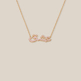 Gold necklace with a bow-shaped pendant on a beige background